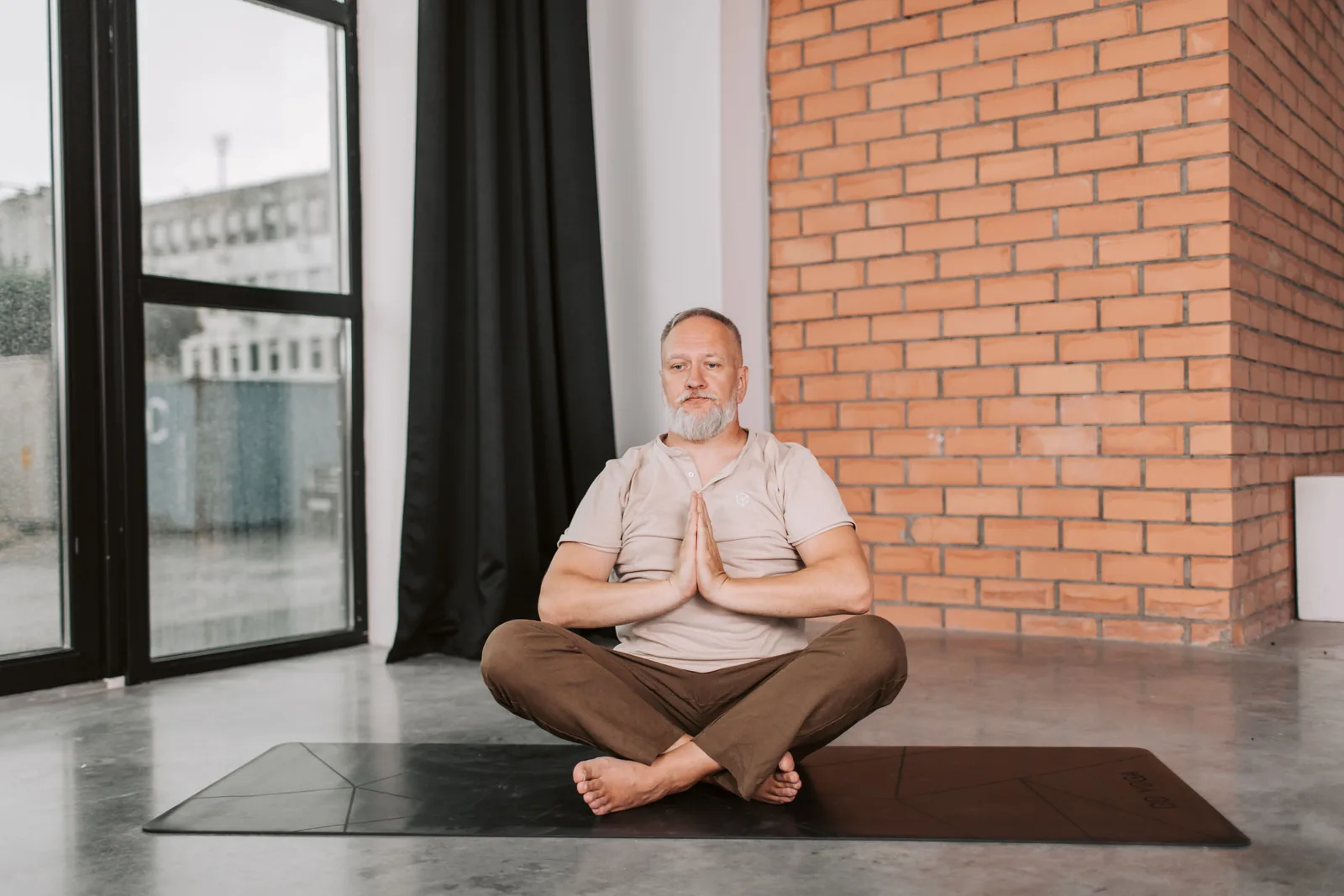 Older man practising gentle yoga and mindful breathing